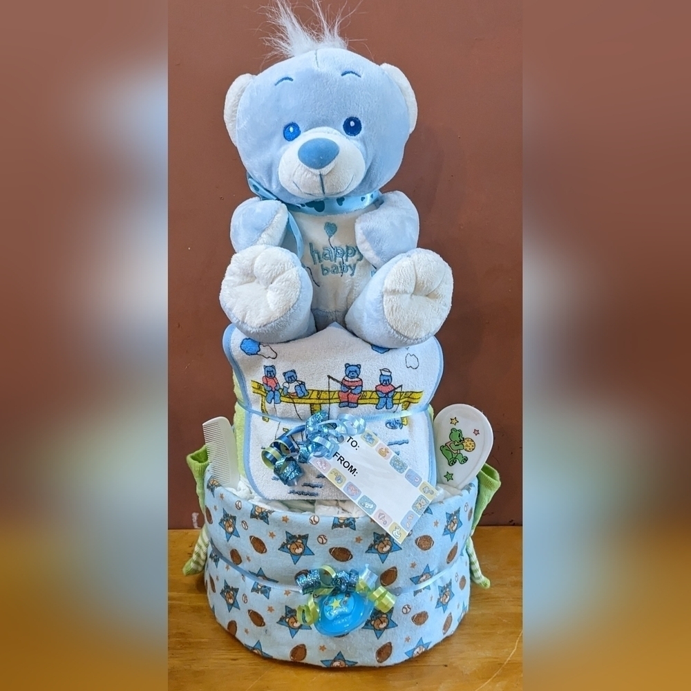 Blue 2 tier baby shower bear diaper cake, bib, bootie socks, hat, gloves, brush